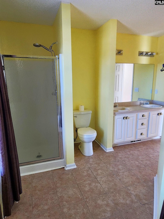 bathroom with tile patterned floors, toilet, an enclosed shower, a textured ceiling, and vanity