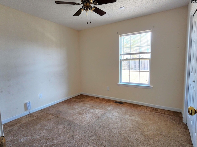 carpeted spare room with ceiling fan and a textured ceiling