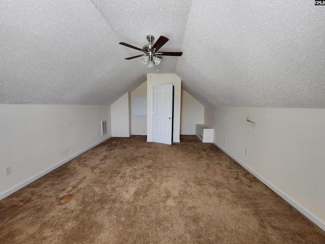 additional living space featuring ceiling fan, lofted ceiling, carpet floors, and a textured ceiling