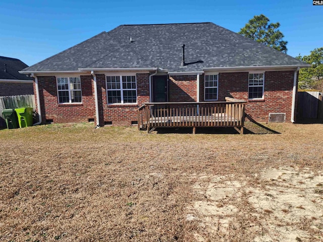 back of property with a wooden deck and a yard