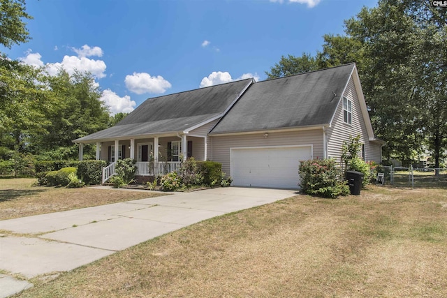 view of front of property featuring a front yard, a porch, and a garage