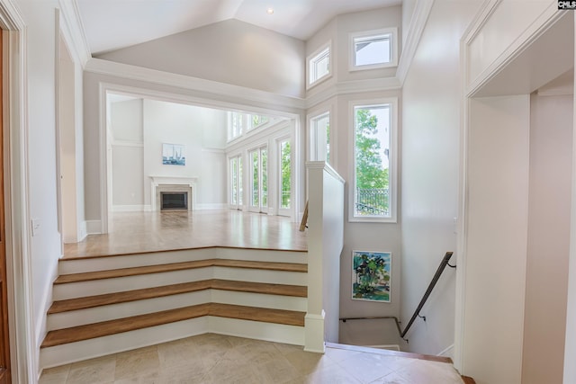 stairs featuring tile patterned floors and high vaulted ceiling