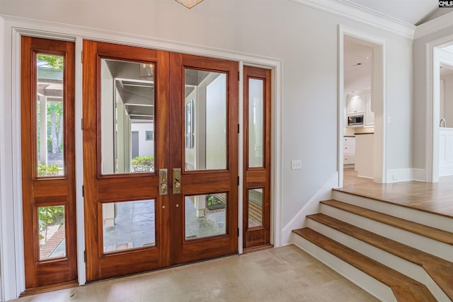 tiled foyer featuring ornamental molding and french doors