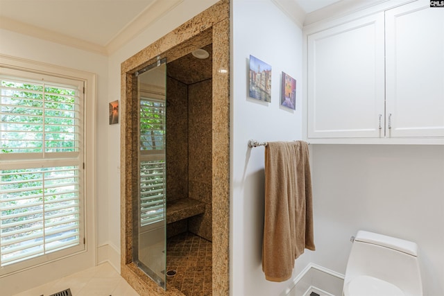 bathroom with tile patterned floors, ornamental molding, toilet, and a tile shower