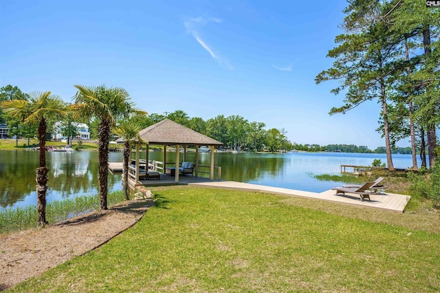 view of dock with a water view and a lawn