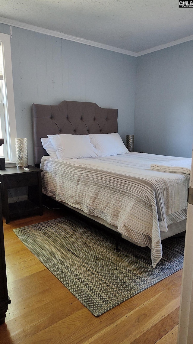 bedroom featuring hardwood / wood-style flooring and crown molding