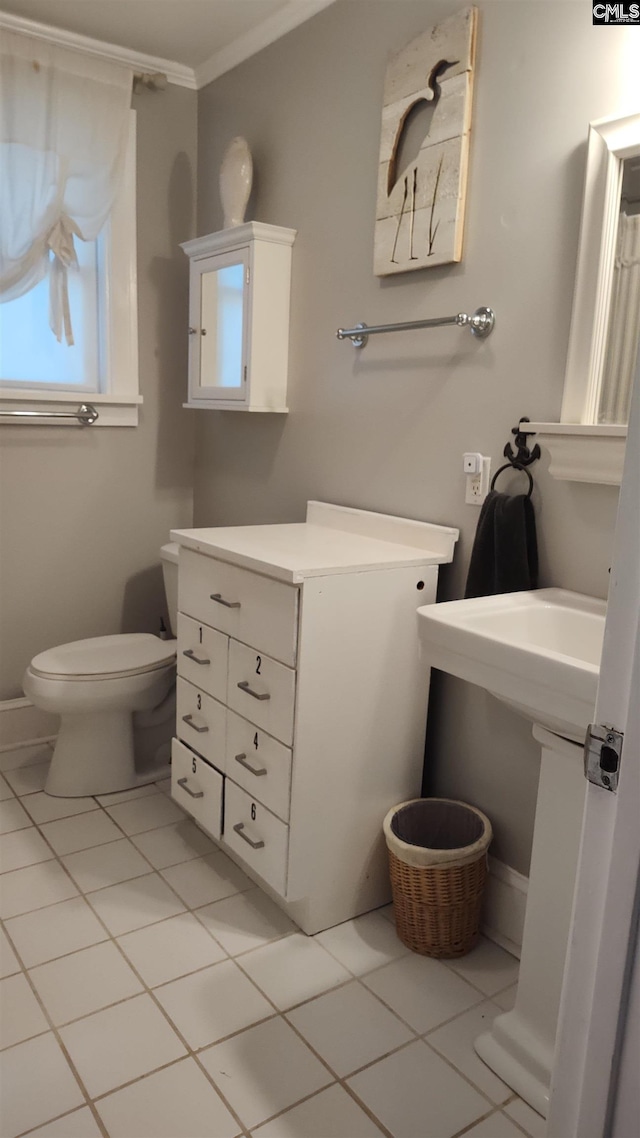 bathroom featuring toilet, tile patterned flooring, and crown molding