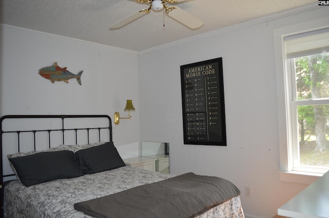 bedroom featuring ceiling fan, crown molding, and a textured ceiling