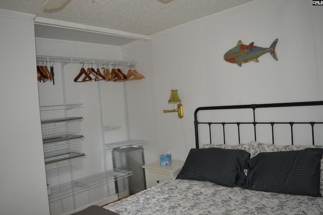 bedroom with ceiling fan, crown molding, and a textured ceiling