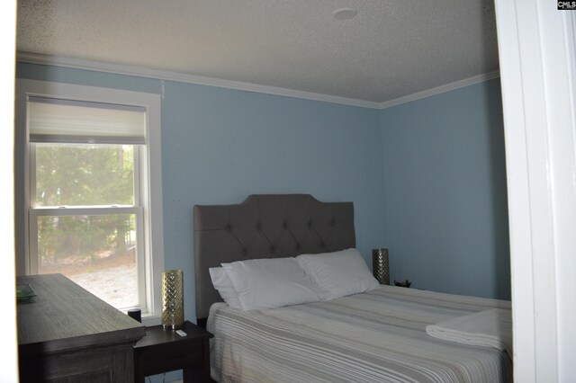 bedroom featuring ornamental molding and a textured ceiling