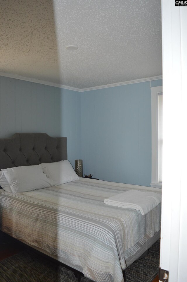 bedroom featuring ornamental molding, carpet floors, and a textured ceiling