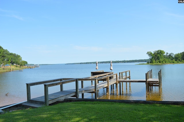 dock area featuring a water view and a lawn