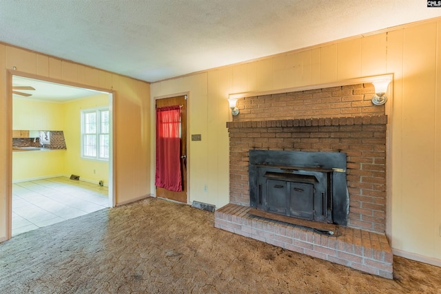 unfurnished living room with baseboards, a textured ceiling, visible vents, and carpet flooring