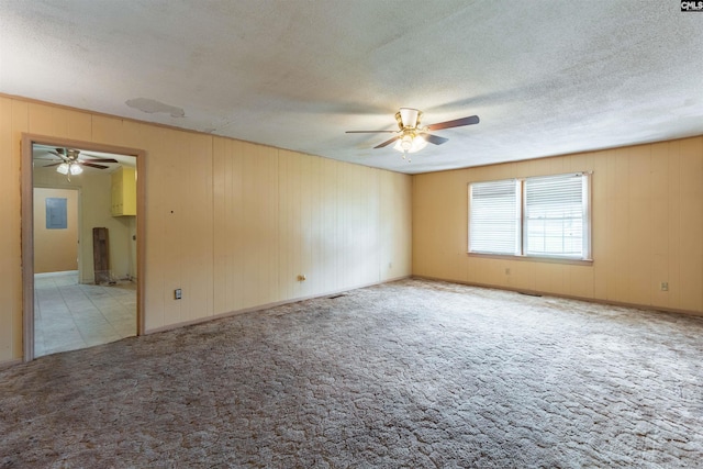 spare room featuring a textured ceiling, ceiling fan, and carpet