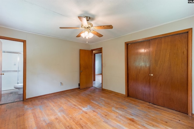 unfurnished bedroom featuring light wood finished floors, baseboards, ornamental molding, and a closet