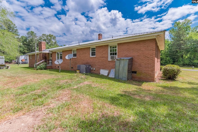 back of house with crawl space, a yard, a chimney, and brick siding