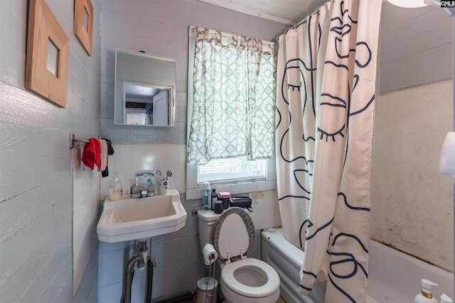 full bathroom featuring toilet, shower / bath combo with shower curtain, and a sink