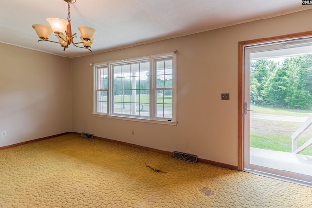 empty room with light colored carpet, visible vents, a notable chandelier, and baseboards