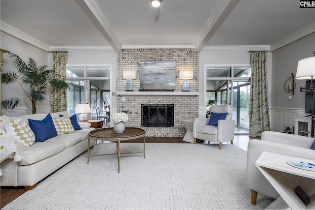 living room with crown molding, hardwood / wood-style flooring, and a brick fireplace