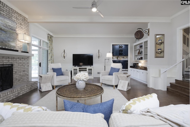 living room with ceiling fan, ornamental molding, dark hardwood / wood-style floors, and a brick fireplace