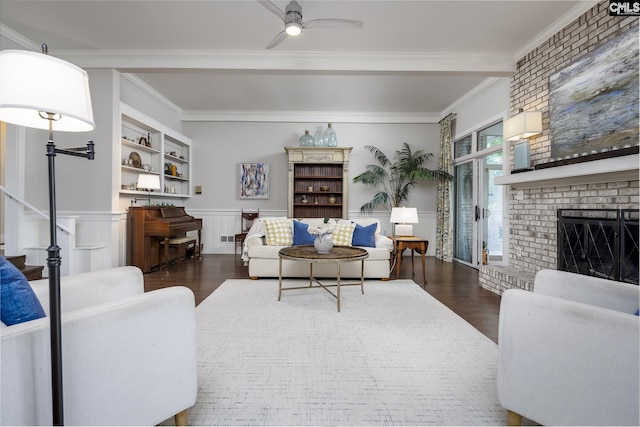 living room with ceiling fan, built in features, crown molding, and dark hardwood / wood-style floors