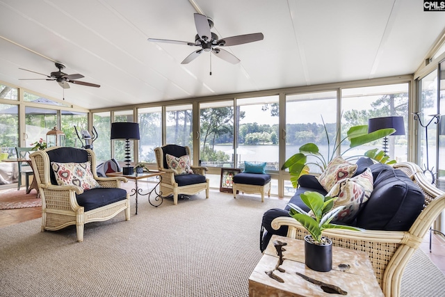 sunroom with ceiling fan, a water view, and a wealth of natural light