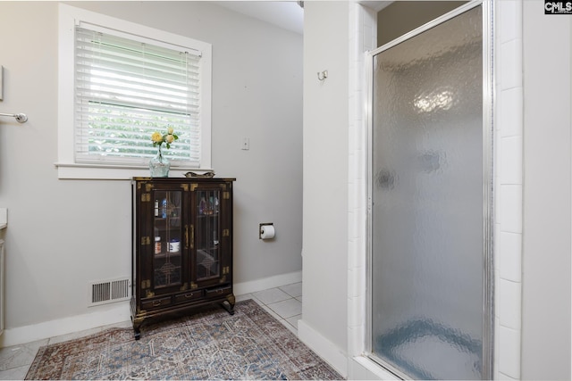 bathroom with tile patterned floors and a shower with door