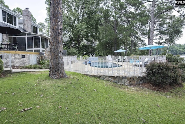 view of pool with a sunroom, a yard, and a patio