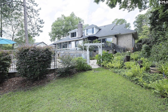 back of house featuring a lawn and a pergola