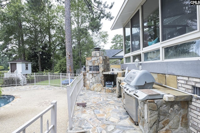 view of patio / terrace with area for grilling and a storage shed