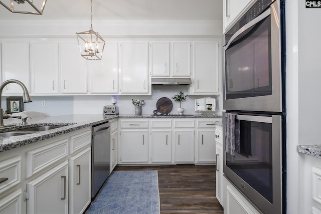 kitchen featuring white cabinets, dishwasher, sink, and hanging light fixtures