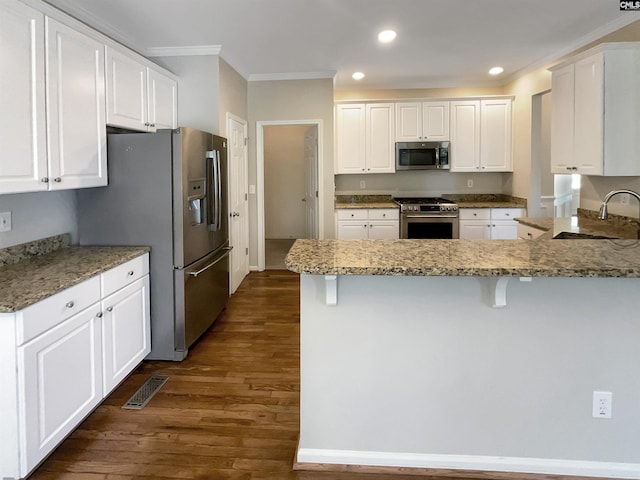 kitchen featuring white cabinets, stainless steel appliances, crown molding, and sink