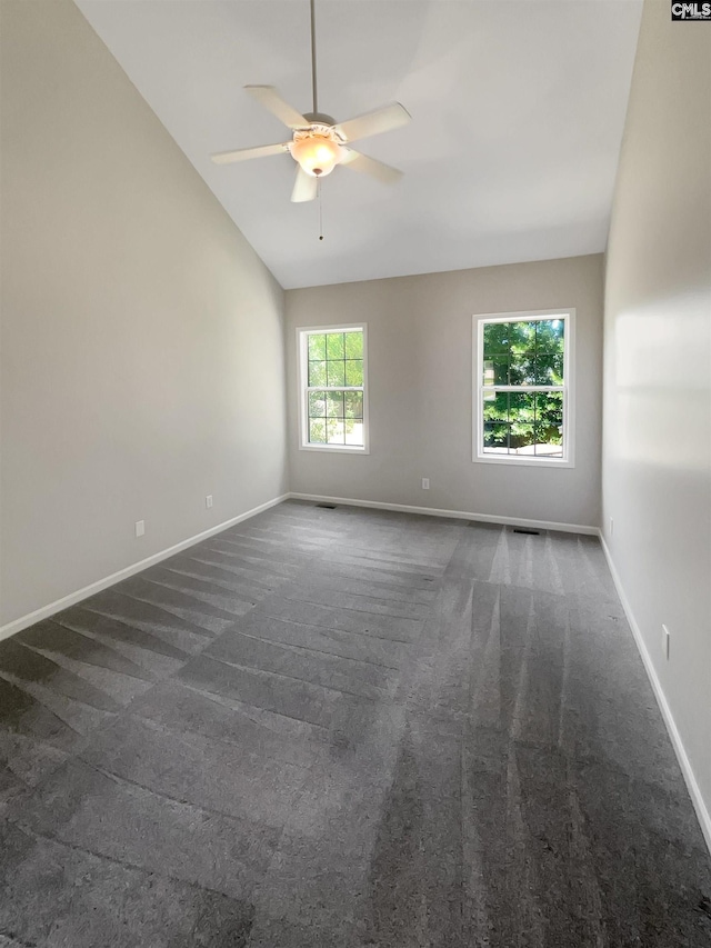 carpeted spare room featuring ceiling fan and vaulted ceiling