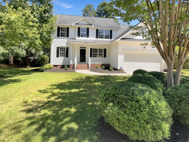 view of front of house with a front yard, a garage, and covered porch