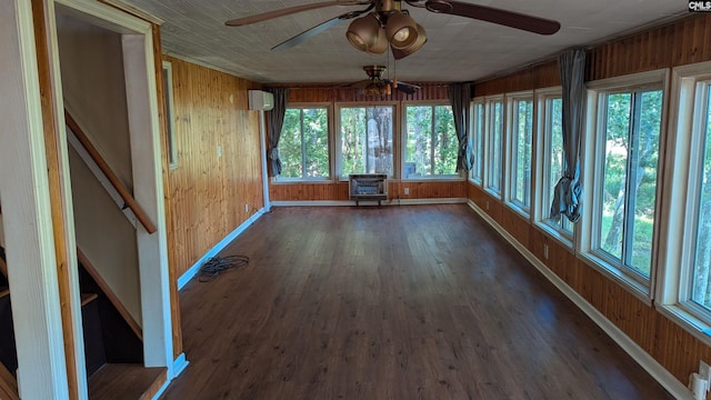 unfurnished sunroom featuring a ceiling fan, an AC wall unit, and heating unit