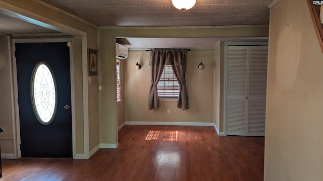 foyer featuring crown molding, baseboards, wood finished floors, and a wall mounted AC