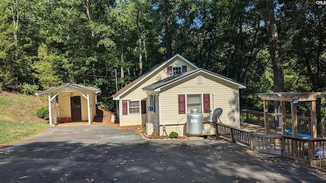 view of front facade with aphalt driveway and an outdoor structure