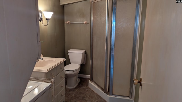 bathroom featuring toilet, a shower stall, vanity, and baseboards