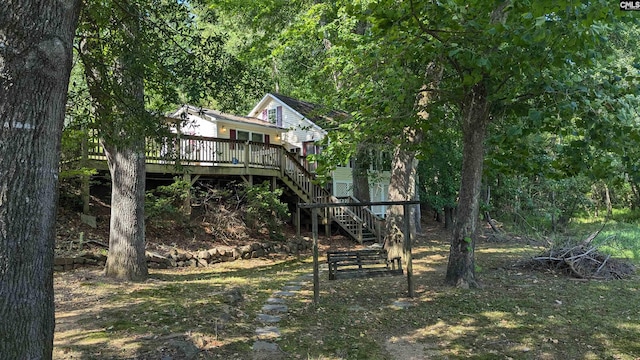 back of house with a forest view, stairway, and a wooden deck