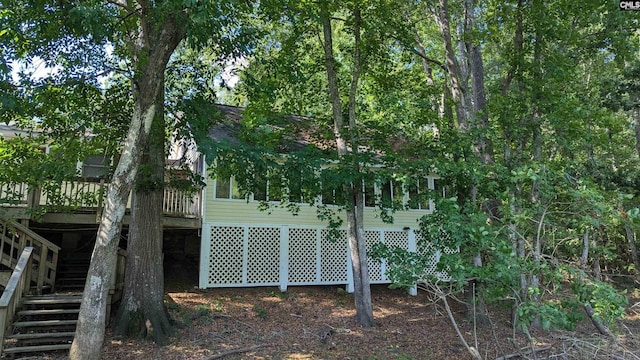 view of side of property featuring stairs and a deck