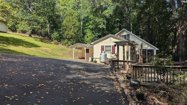 bungalow-style home with a forest view and a front lawn