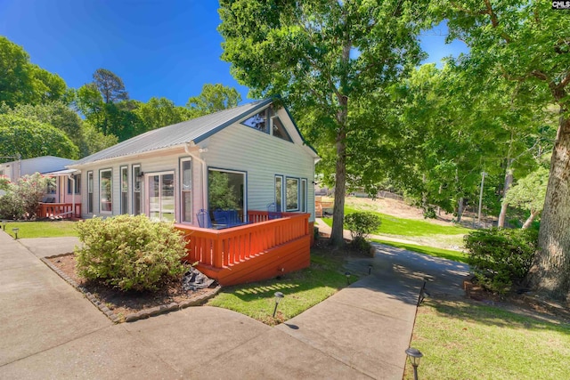 view of property exterior with a wooden deck and a lawn