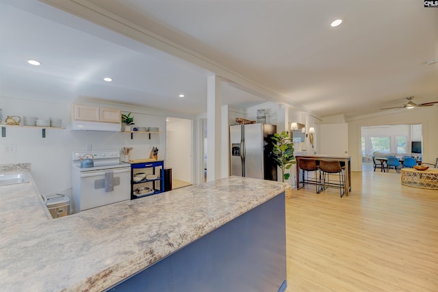 kitchen with electric range, light hardwood / wood-style flooring, ceiling fan, stainless steel fridge, and sink