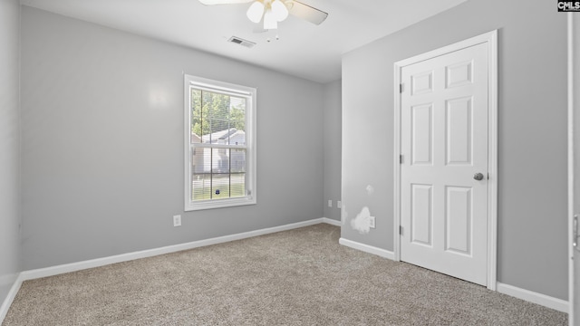 carpeted spare room featuring ceiling fan