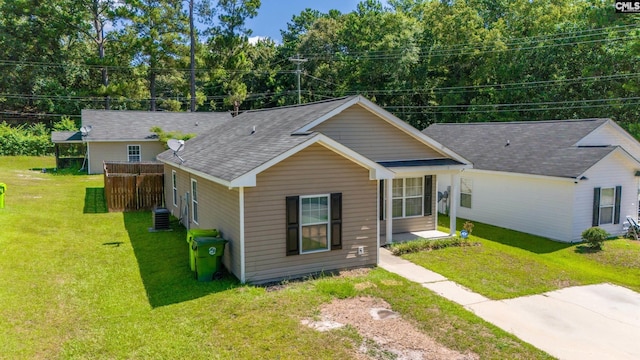 ranch-style house with cooling unit and a front lawn