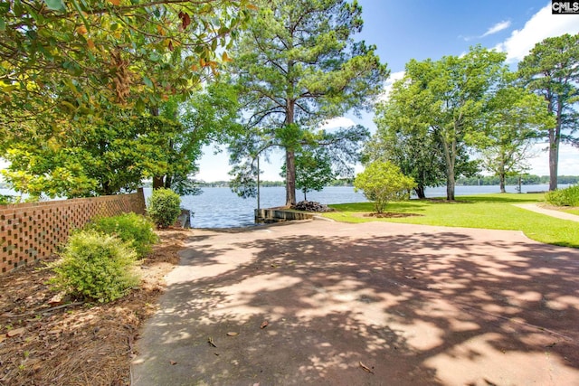 exterior space featuring a water view and a front lawn