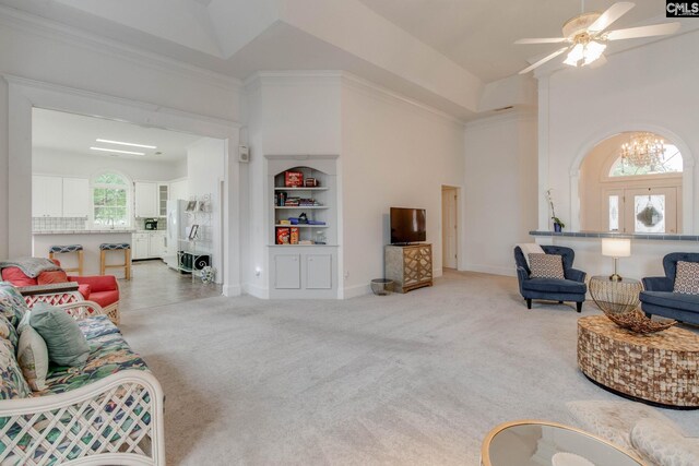 living room with ornamental molding, carpet flooring, and ceiling fan