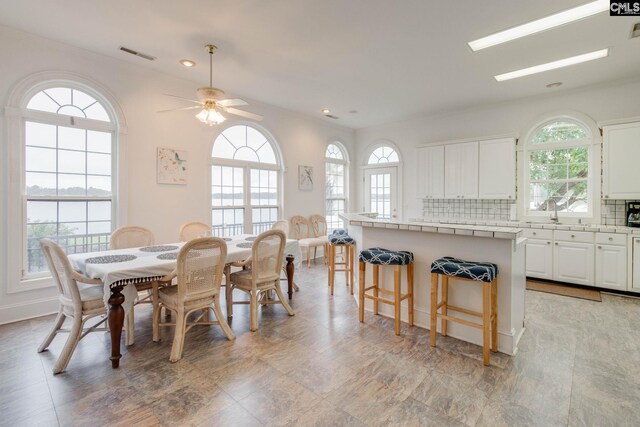 tiled dining space with sink and ceiling fan