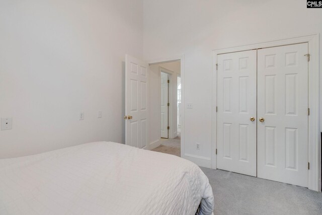 bedroom featuring a closet and light colored carpet