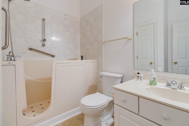 bathroom featuring vanity, tile patterned flooring, and toilet